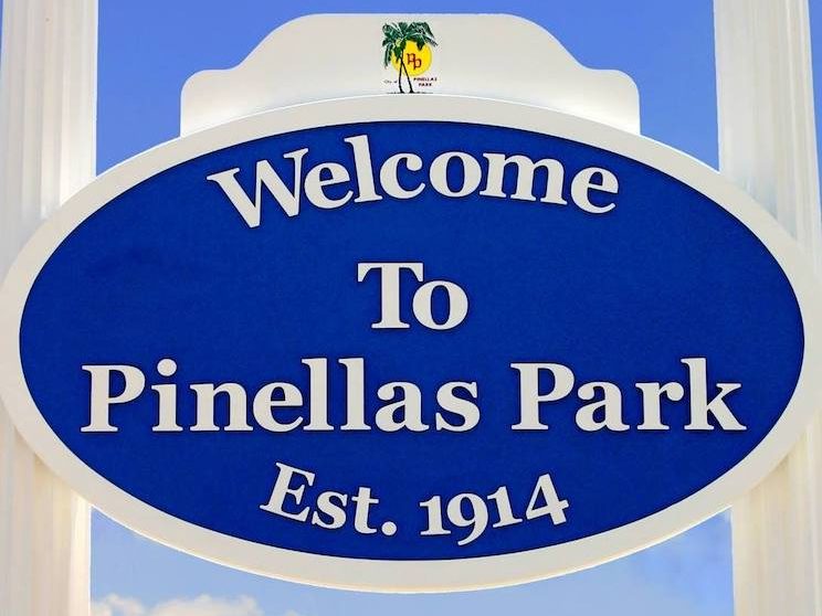 a blue and white sign that says "Welcome to Pinellas Park, est. 1914."