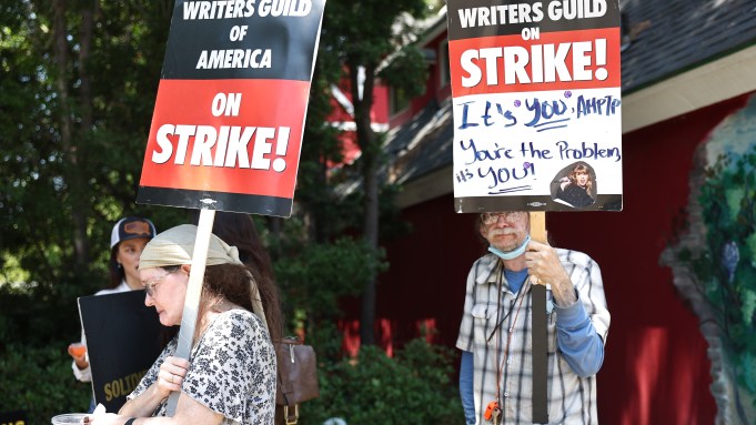 BURBANK, CALIFORNIA - JULY 17: People hold signs in support of striking WGA (Writers Guild of America) members on Day 5 outside Warner Bros. Studio on July 17, 2023 in Burbank, California. Members of SAG-AFTRA, HollywoodÔÇÖs largest union which represents actors and other media professionals, have joined the striking writers in the first joint walkout against the studios since 1960. The strike could shut down Hollywood productions completely with writers in the third month of their strike against the Hollywood studios. (Photo by Mario Tama/Getty Images)