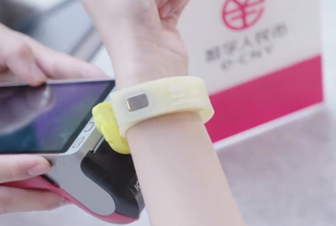 A customer uses a wearable offline ÔÇ£hardÔÇØ digital yuan (CBDC) wallet to pay in a store.