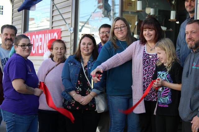 Apryll Letteer cuts the ceremonial ribbon during Saturday┬Æs grand opening for Unique Giftique on West Main Street in Plymouth.
 Hannah Simerson | Times Leader