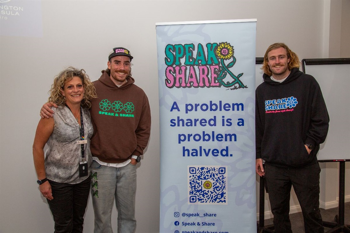 three people smiling at camera in front of Speak and Share banner.jpg