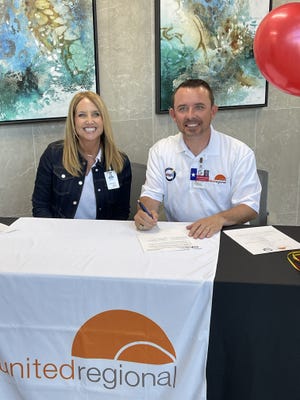 Kristi Faulkner, vice president of organizational development for United Regional Health Care System, left, and Dr. Donny Lee, superintendent of Wichita Falls ISD, sign off on a new partnership to provide athletic care for student on Tuesday at the United Regional Center for Advanced Orthopedics.