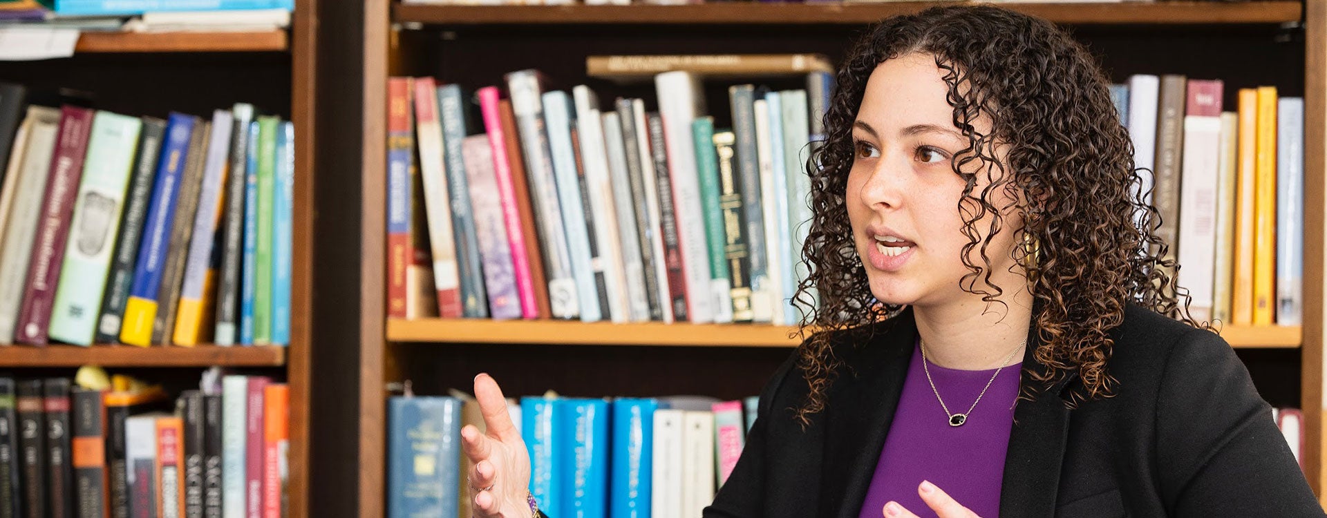 ECU student Dana Shefet speaks at a conference room table during her experience as Dean for a Day.