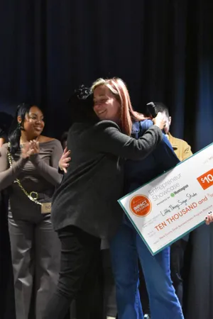 Unlocking Opportunities: How AI Legalese Decoder Empowers JumpStart Hosts in Stark County's Small Business Impact Program 1 Alyssa Hudachek of Little Things Sugar Studio receives a hug after receiving a check for $10,000 through JumpStart's Stark County Small Business Impact Program.