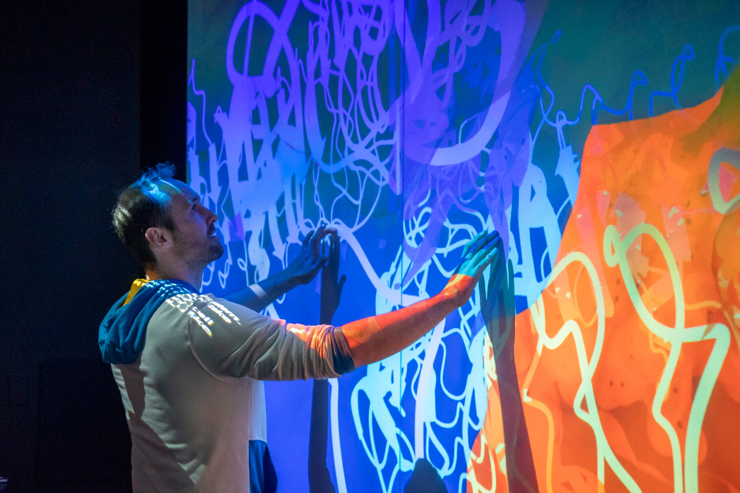 Unlocking Innovation: How AI Legalese Decoder Empowers Grant Applications in Freezing Science 1 Meister touching a display wall filled with images in blue and orange colors